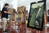 Pengunjung melihat lukisan yang dipajang dalam pameran bertajuk Project Exhibition di Gedung DPRD Kota Malang, Jawa Timur, Selasa (20/5/2025). Pameran dalam rangka hari Kebangkitan Nasional tersebut berlangsung hingga Minggu (25/5) dan menampilkan puluhan lukisan dari 16 seniman yang tergabung dalam Komunitas Malang Suko dengan mengangkat tema Mei Berseri. ANTARA Jatim/Ari Bowo Sucipto/mas.