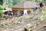 SAR gabungan bergotong-royong menyingkirkan material longsor yang menimbu rumah warga di Desa Depok, Trenggalek, Jawa Timur, Rabu (21/5/2025). Operasi SAR gabungan untuk mengevakuasi enam korban longsor yang dilaporkan hilang pada hari kedua di permukiman kaki lereng Gunung Wilis ini masih berfokus pada normalisasi akses jalan untuk mempermudah mobilisasi alat berat, sementara di titik longsor utama pencarian masih dilakukan secara manual karena sulitnya medan dan banyaknya titik longsor yang menutup jalan. ANTARA Jatim/Destyan Sujarwoko/mas.