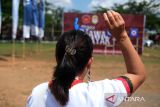 Seorang peserta mencabut anak panah yang tertancap pada rambut di kepalanya saat mengikuti Lomba Menyumpit dalam rangka Pekan Gawai Dayak ke-39 di Rumah Radakng, Pontianak, Kalimantan Barat, Kamis (22/5/2025). Lomba ketangkasan menyumpit dengan jarak tembak 15 meter yang diikuti 89 peserta pria dan wanita dari berbagai sanggar budaya serta instansi pemerintah tersebut bertujuan melestarikan olahraga tradisional Suku Dayak. ANTARA FOTO/Jessica Wuysang